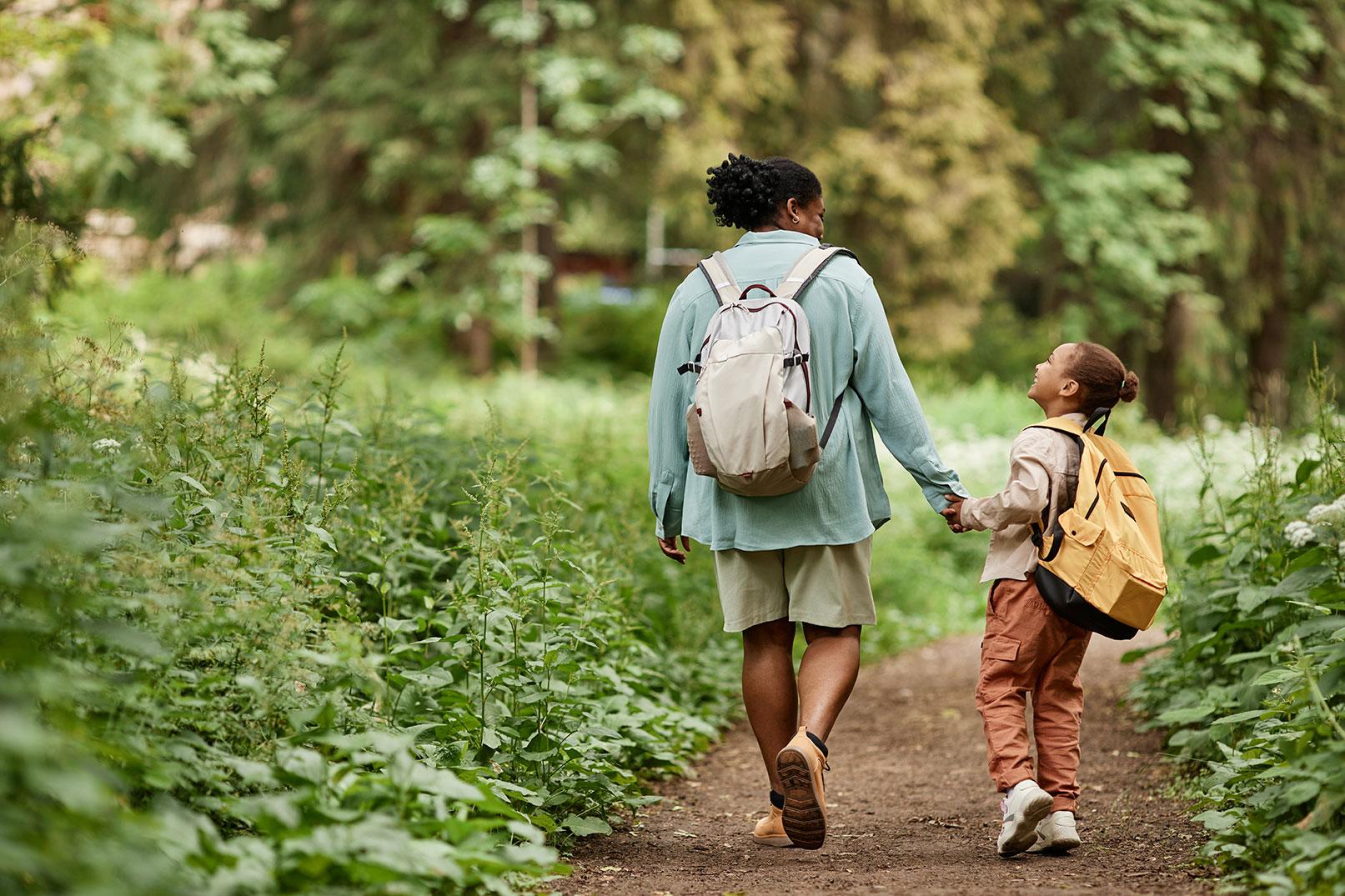 A parent and child exploring a woodland path