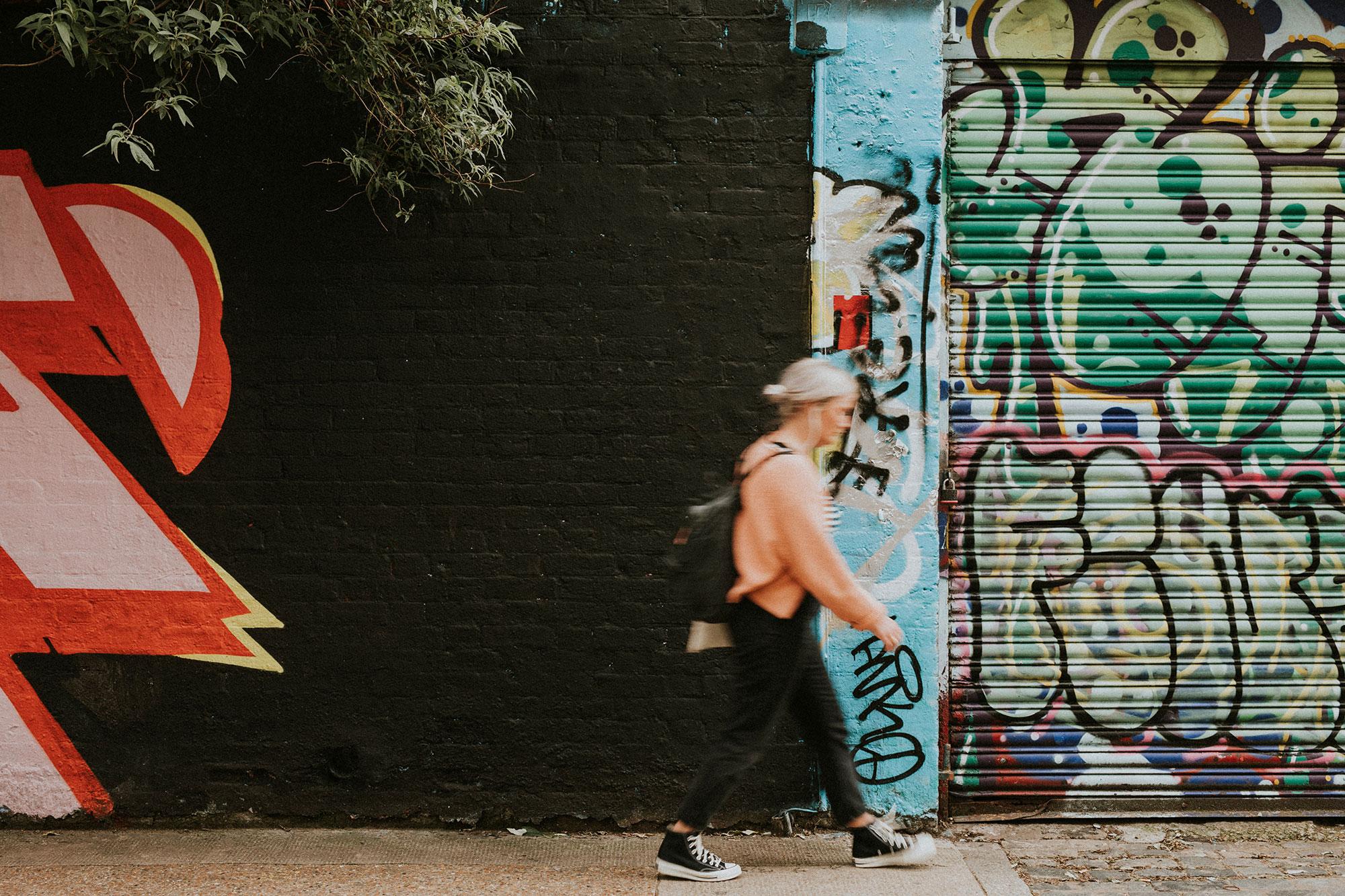 A visitor exploring a street art alley